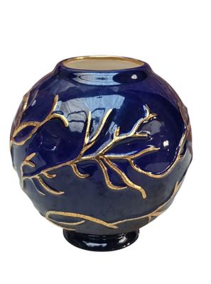 a blue vase with a gold leaf design on it