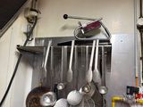 pots and pans hanging on a wall in a kitchen