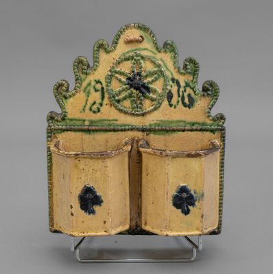 une image représentant un vase jaune et vert avec deux portes ouvertes
