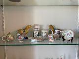 a glass shelf that has a lot of china on it