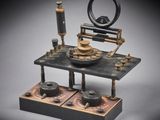 an old model of a machine with a clock on it