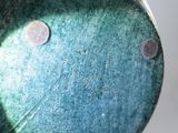 a close up of a green vase with dots on it
