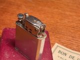 un briquet posé sur une boîte, elle-même posée sur une table