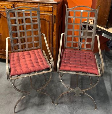 une paire de chaises en métal avec des coussins rouges dans une pièce aux murs orange