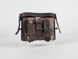 un vieux sac en cuir posé sur un support métallique