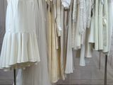 a lot of dresses hanging on a rack in a room