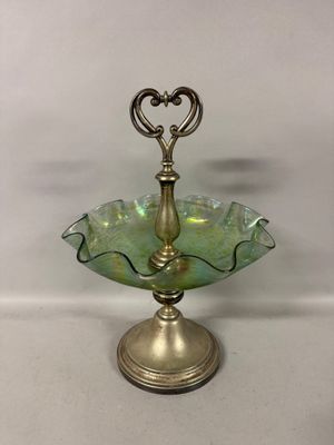 an image of a green glass bowl on a stand with a heart shaped handle
