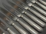 a lot of knives that are lined up on a table