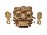 un masque en bois devant lequel se trouvent deux cuillères en bois