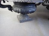 a black vase with a metal lid sitting on a table