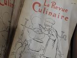 un livre sur lequel figure la photo d'une femme en train de cuisiner dans une cuisine