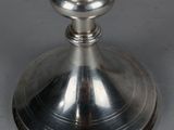 an antique silver plated candle holder with a candle on top
