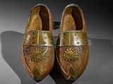 pair of leather shoes with gold decoration on them on display