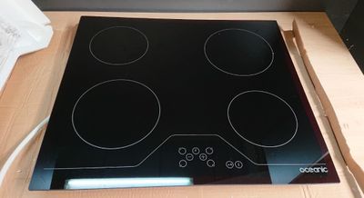 a black stove top with four burners on it