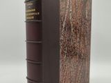 un vieux livre à la couverture brune posé sur une table