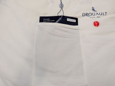 Le t-shirt est blanc et comporte une étiquette noire.