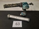 une perceuse et un tuyau posés sur une table à côté d'un panneau