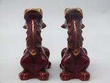 pair of red and gold figurines of a dog and a cat