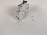 un gros plan d'un disjoncteur miniature posé sur une surface blanche