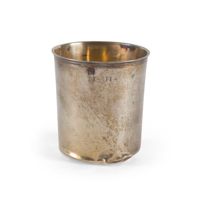 une tasse en argent posée sur une surface blanche