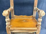 an old wooden chair with a mirror on the back of it