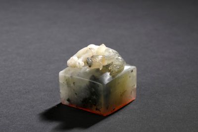an image of a piece of green and white jade on a black surface