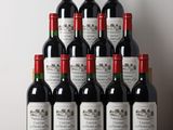 Des bouteilles de vin rouge sont posées sur une table devant un mur blanc.