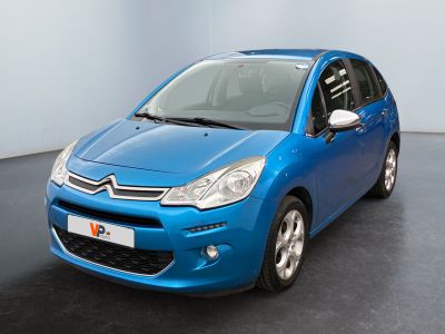 the small blue car is parked in a room with a black floor