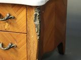 a small wooden table with a marble top on it