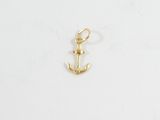 un pendentif en forme d'ancre dorée sur fond blanc