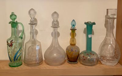 many different glass vases on a shelf in a room