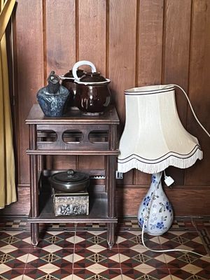 une petite table sur laquelle se trouvent une lampe et un vase
