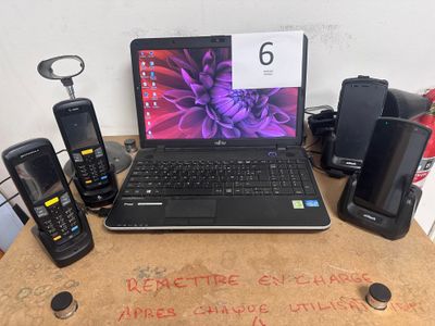 Plusieurs téléphones portables et un ordinateur portable sont posés sur une table