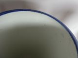 a close up of a blue and white cup on a table