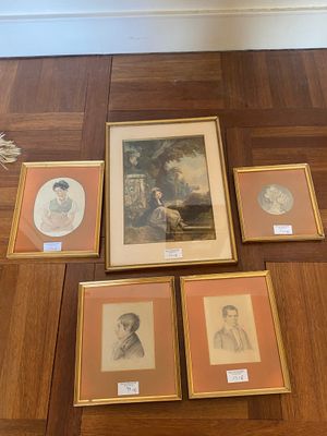 four framed pictures on the floor of a room