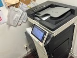 une imprimante posée sur un bureau, à côté d'une chaise