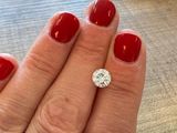 un gros plan sur la main d'une personne arborant une manucure rouge et une bague en diamant