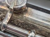 a close up of a silver flute with a button on it