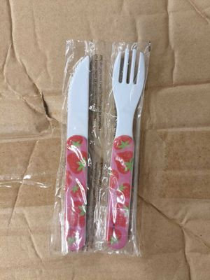 deux fourchettes en plastique et deux cuillères en plastique dans l'emballage