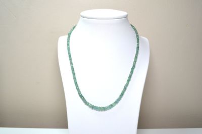 collier composé de perles de verre vertes sur un mannequin blanc