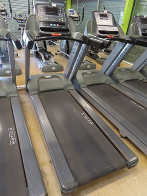 row of treads in a gym room with mirrors on the wall
