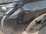 a close up of a black car with a denting on it