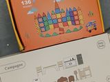 a box of magnetic tiles on the floor next to a box of magnets