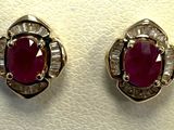 deux paires de boucles d'oreilles en rubis et diamants posées sur un fond blanc