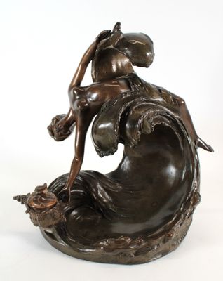 statue en bronze représentant une femme assise sur une vague, tenant un poisson