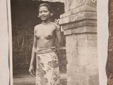 an old photo of a man standing in front of a stone building