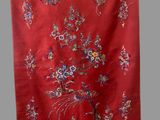 an image of a red cloth with flowers and birds on it
