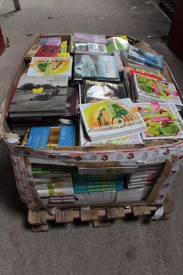 une caisse remplie de livres posée sur le trottoir