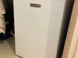 a small white refrigerator in the corner of a room