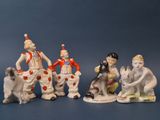 cinq figurines de clowns assis sur une surface bleue